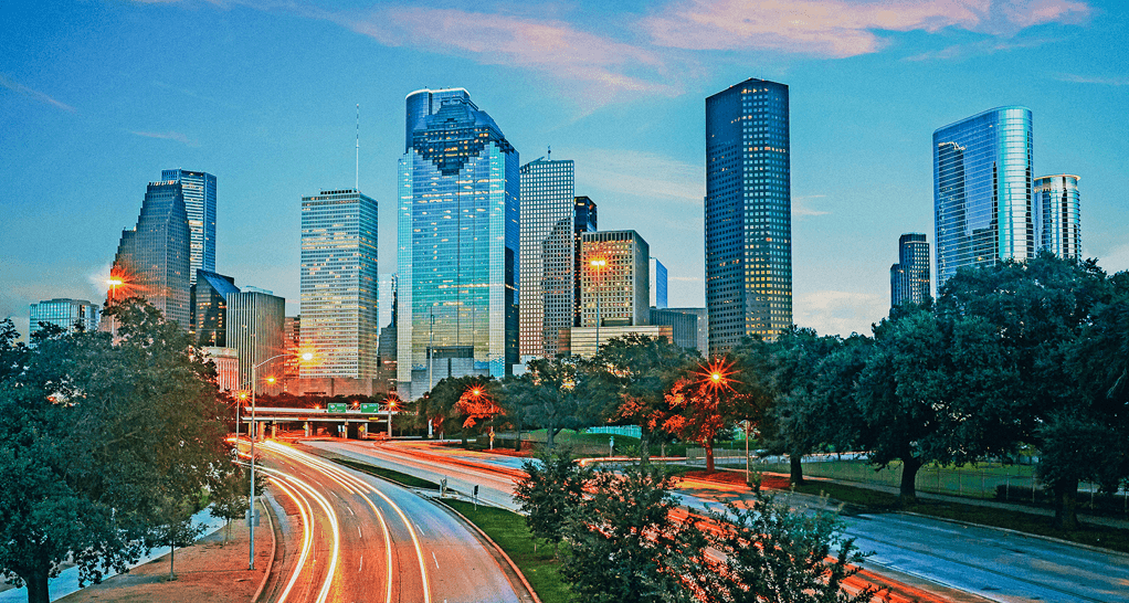 Houston skyline at dusk with downtown high-rises and highway light trails, featured image for a Q&A with Matthews™ Houston Market Leader Patrick Graham
