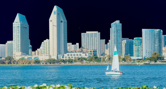 ailboat on the San Diego Bay with the downtown skyline in the background, featuring the Manchester Grand Hyatt and surrounding high-rise buildings, used for Matthews™ press release on agents named finalists in the San Diego Business Journal’s Commercial Real Estate Award